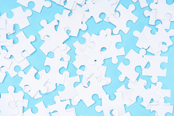 full frame of white puzzles arrangement on blue backdrop
