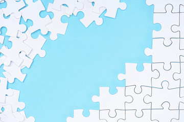 full frame of white puzzles arrangement on blue backdrop