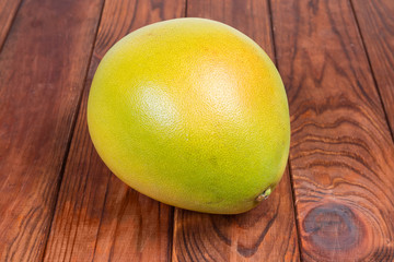 Ripe pomelo on a dark colored rustic table