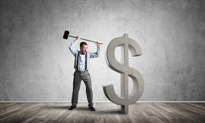 Determined banker man in empty concrete room breaking dollar figure