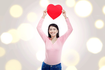 Pretty asian woman with red heart on her hands