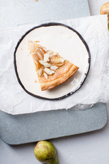 A slice of tart with poached pears and almond frangipane