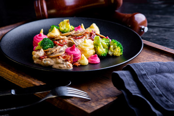 delicious Beef Strogans Restaurant Dish in restaurant background. Healthy exclusive food on big black platter closeup