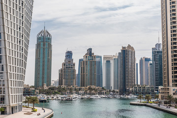 Dubai, United Arab Emirates - October, 2018: Promenade and canal in Dubai Marina with luxury skyscrapers around, United Arab Emirates