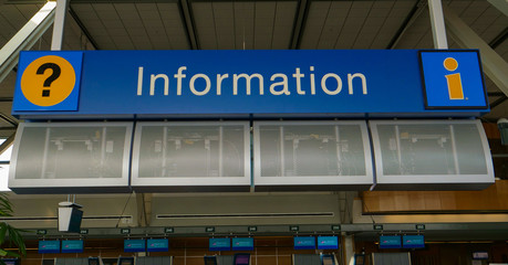 CLOSE UP Bright blue information desk sign hangs from the ceiling at the airport