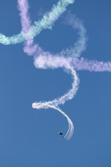 Parachutist with spiral clouds of smoke over San Diego, California