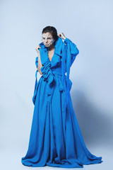 Naklejka premium Woman with a pieces of glass or ice on her face, wearing beautiful blue dress