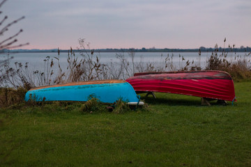 two boats  in the grass near the lake