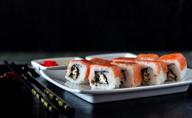 Traditional Japanese cuisine. Philadelphia sushi roll made of fresh salmon, avocado and cream cheese with black rice