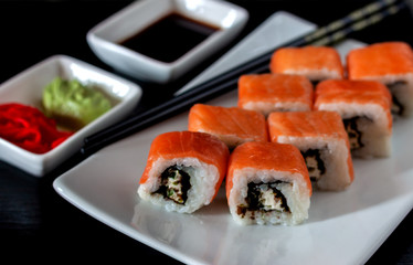 Traditional Japanese cuisine. Philadelphia sushi roll made of fresh salmon, avocado and cream cheese with black rice