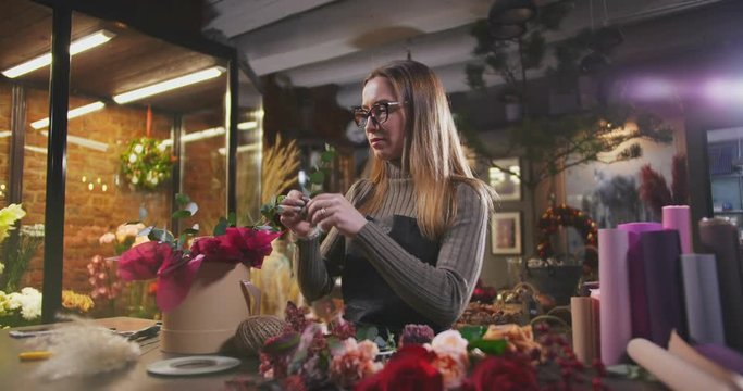 The flower shop seller making flower arrangement for customer