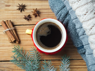 Obraz na płótnie Canvas hot coffee and cozy home background. warm knitted sweaters, Christmas tree branches and cinnamon sticks