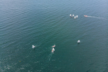 Fototapeta na wymiar Aerial drone photo of young teenagers on small sailing boats competing in the regatta at mediterranean emerald sea