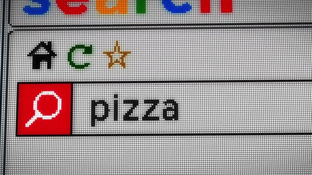Searching for pizza on the Internet. Typing keyword in www browser on computer, smartphone or tablet. Close view of screen display with pixels.