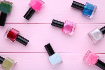 Group of bright nail polishes on pink background