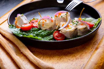 delicious Restaurant Dish Vitello Tonato in restaurant background. Healthy exclusive food on big black platter closeup