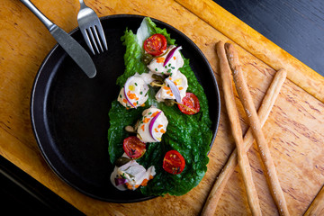 delicious Restaurant Dish Vitello Tonato in restaurant background. Healthy exclusive food on big black platter closeup