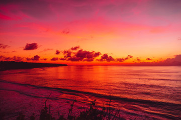 Fototapeta na wymiar Ocean with waves and bright sunset or sunrise in Bali. Ocean with sunset colors