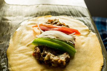 making venezuelan christmas dish hallacas with all ingredients on table with italian flag colors