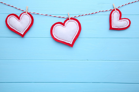 Valentines day greeting card. Handmaded hearts on a rope on blue background.