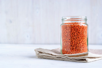 Glass jar filled with orange or red lentils