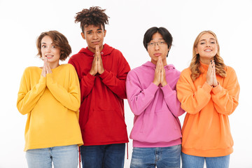 Obraz premium Friends students standing isolated over white wall background showing pray gesture.