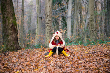 red dressed Cute girl is happy in the forest at autumn season