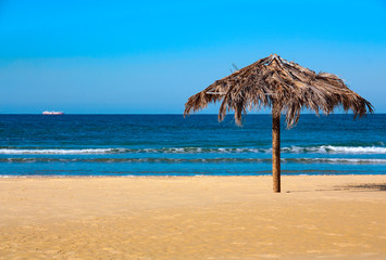 Fototapeta na wymiar A beach umbrella made of palm leaves