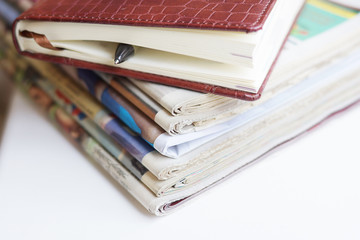 Business Diary with Leather Textured Cover and Newspaper Pages with Headlines and Articles. Tabloid Journals with Latest News and Financial Data, Business Concept with Copy Space