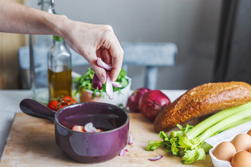 hands of chefs prepare a salad of fresh and healthy ingredients, vegetables and olive oil in the kitchen
