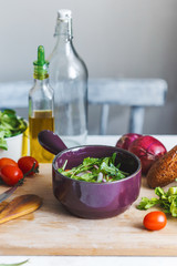 bowl of fresh vegetable salad and ingredients for cooking on the kitchen table