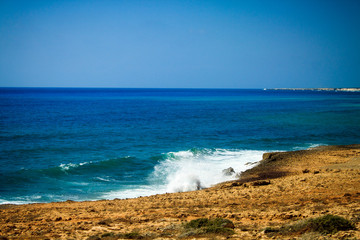 The big waves of the Mediterranean sea beating on the rocky shore on the reserved beach of Lara on the island of Cyprus