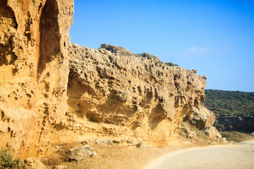 Fototapeta na wymiar Large high rocks on the way to the reserved sandy beach of Lara on the island of Cyprus
