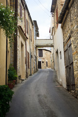 Obraz premium Długie wąskie uliczki składające się ze starych kamiennych domów zbudowanych w jednej linii w wiosce w górach na Cyprze