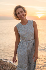 Natural portrait of a blonde woman in a dress near the sea