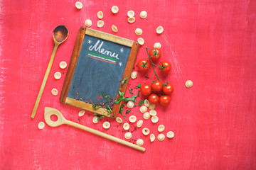 menu template for italian restaurant, orecchiette pasta,wooden spoons, tomatos, flat lay,blackboard with free copy space