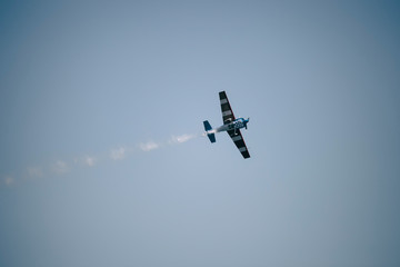 Small airplane doing aerial acrobatics in a exhibition