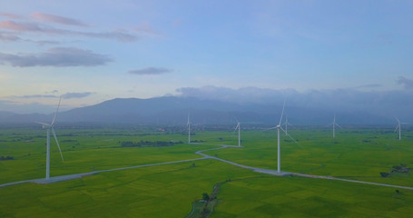 Wind turbine farm and agricultural fields on blue sky. Turbine green energy electricity or wind turbine in a green field - Energy Production with clean and Renewable Energy. Phan Rang, Vietnam