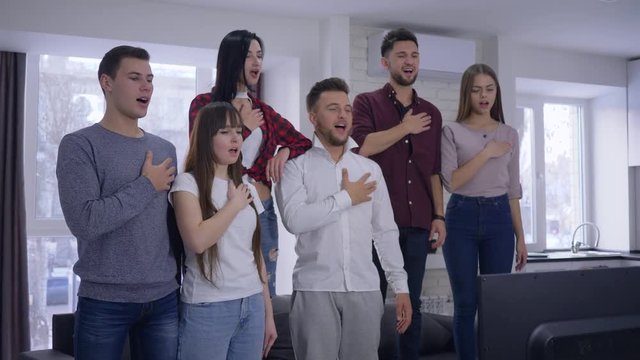 Youth Fans Singing National Anthem Before Watching Sports Championship On TV Together At Home