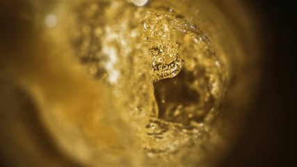 Closeup slow-motion pouring beer in glass. Craft beer closeup. Microbrewery