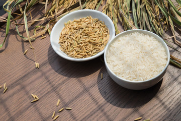Organic Paddy Seeds, Unmilled Rice and white rice on wood background with copy space, healthy food.