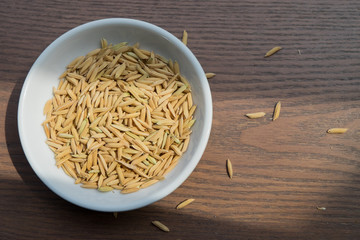 Organic Paddy Seeds, Unmilled Rice on wood background with copy space, healthy food...