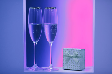 Neon pair of glasses of champagne in the holidays interior.