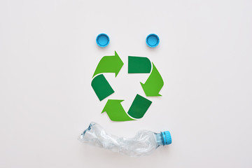 Think about ecology. Isolated recycle symbol and crumple plastic bottle
