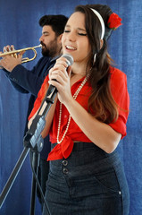 portrait of retro/pin up couple singing and playing trumpet