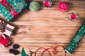 Christmas holiday gift box on decorated festive table with pine cones on wooden background