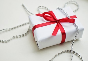 present box with red ribbon on white background for Christmas and New year. Top view.