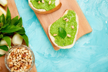 Bruschetta with pesto sauce, parmesan cheese and fresh basil
