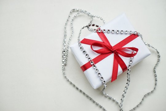 present box with red ribbon on white background for Christmas and New year. Top view.