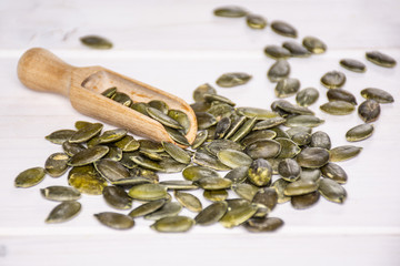 Hulled pumpkin seeds on grey wood